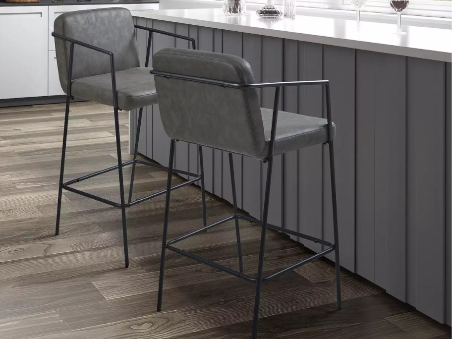 2 grey leather stools at a kitchen island