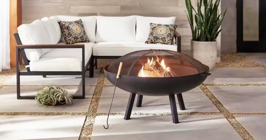 round fire pit in front of a white patio couch