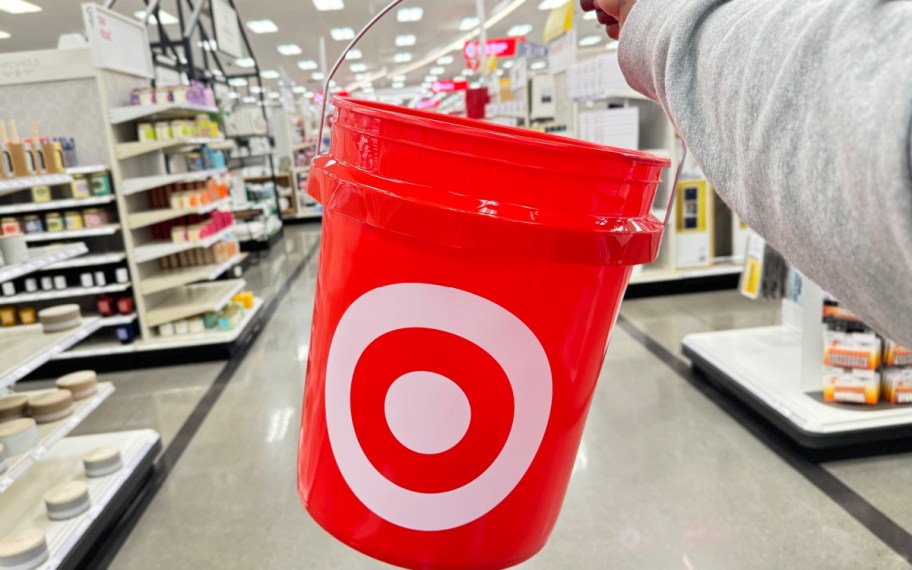 Hand holding red target bucket inside of the store