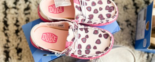 pink hey dude heart shoes on top of shoe box