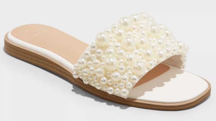 a white slide shoe covered in pearls