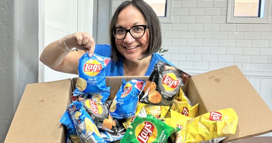 woman holding up a large box of lay's potato chips