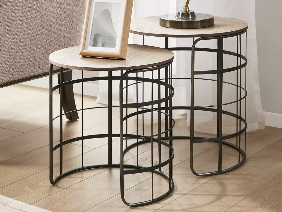 two black nesting end tables with wood tops