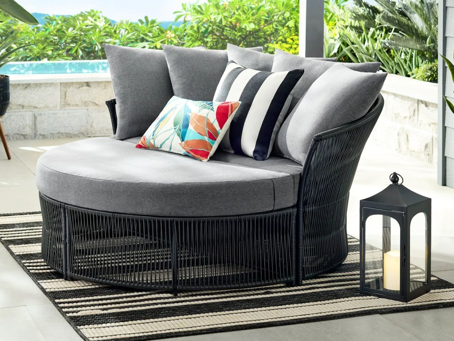 black and grey round outdoor daybed with pillows