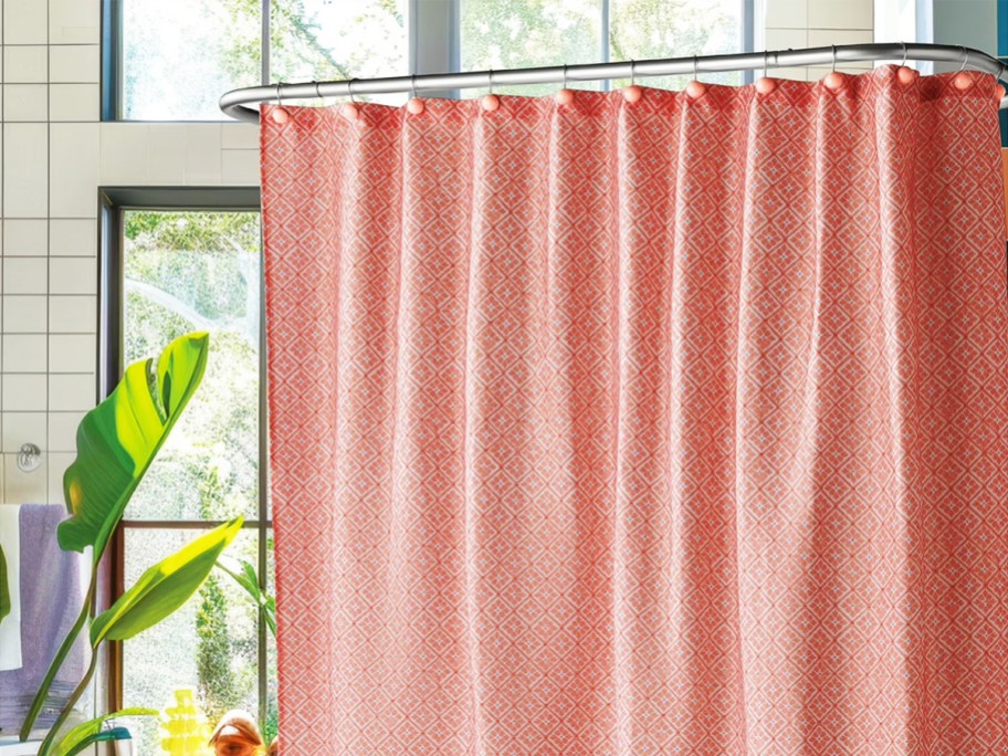 pink shower curtain hanging in front of tub