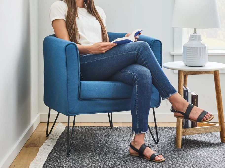 A woman sitting in a Mayview Bucket Chair with Hairpin Legs