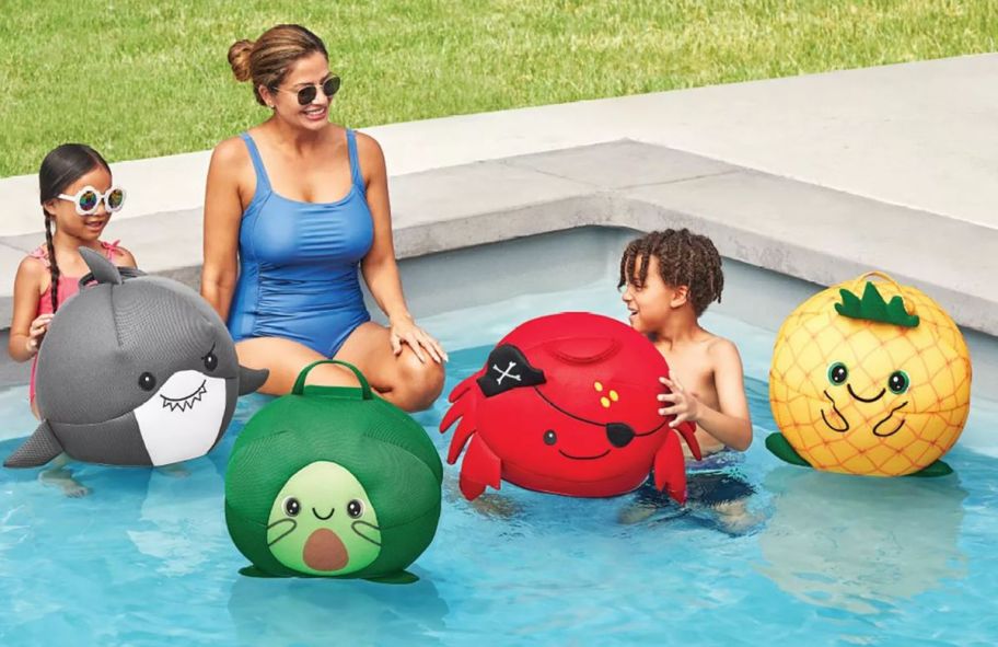 a mom and 2 kids playing in a pool 