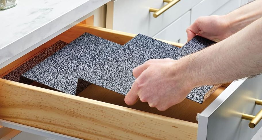 a mans hands placing a metal spice organizer into a drawer