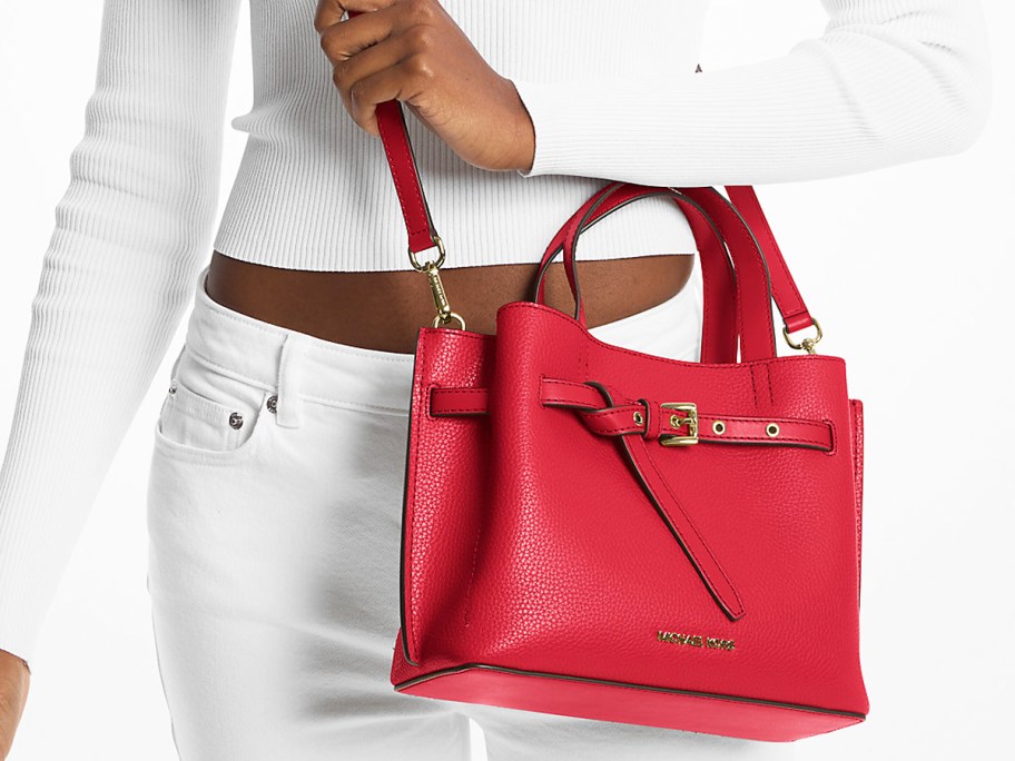 woman in a white outfit with a red purse