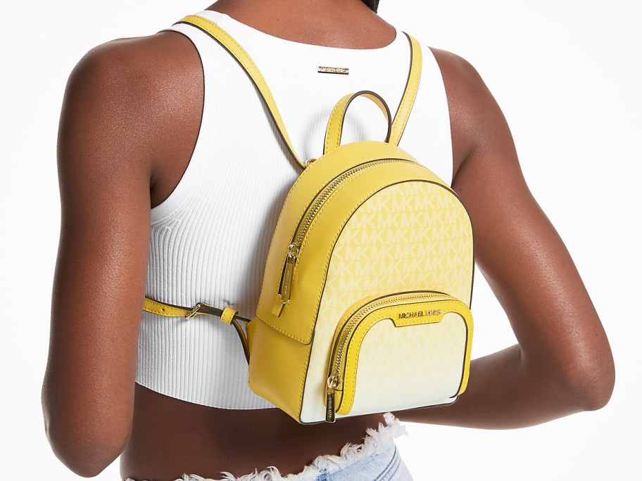 woman in white tank top and yellow mini backpack