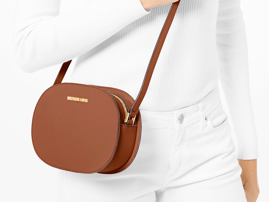 woman in white outfit with brown oval crossbody bag