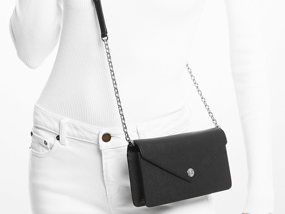 woman in a white outfit with a black crossbody bag