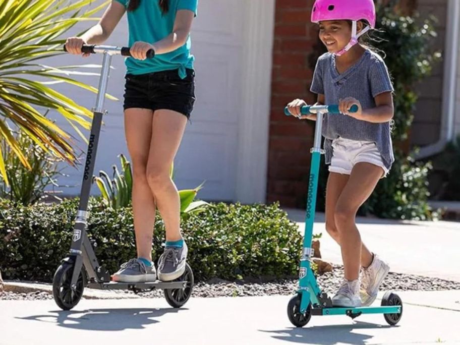 Two children riding Mongoose Trace Folding Scooters