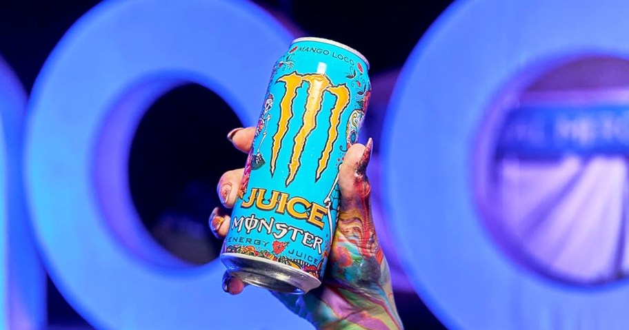 hand holding up a blue monster juice energy drink can