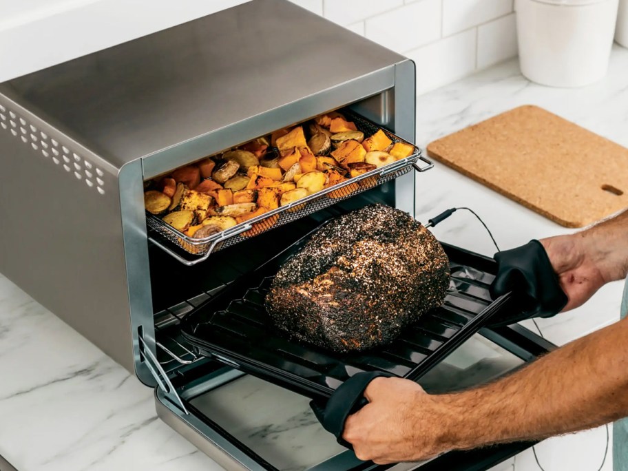 woman cooking roast and potatoes at same time in a ninja oven