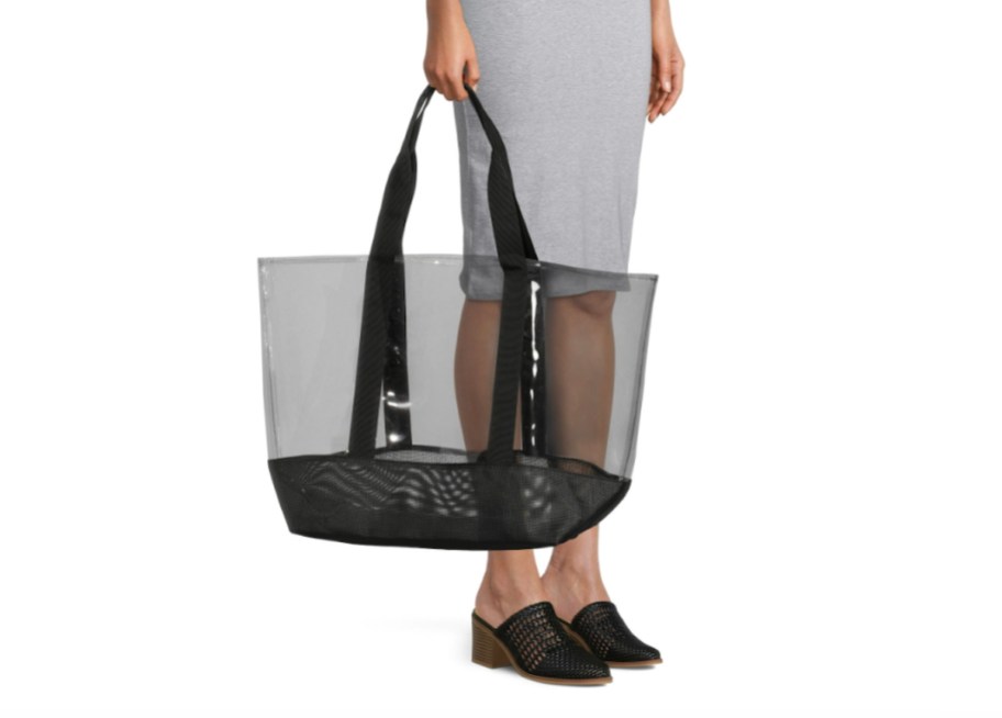 Stock photo of woman carrying clear and black tote bag