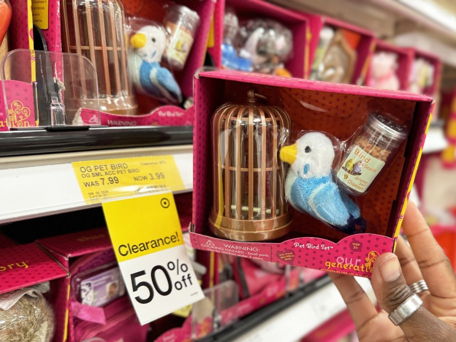 hand holding Our Generation Pet Bird Set near 50% off clearance tag