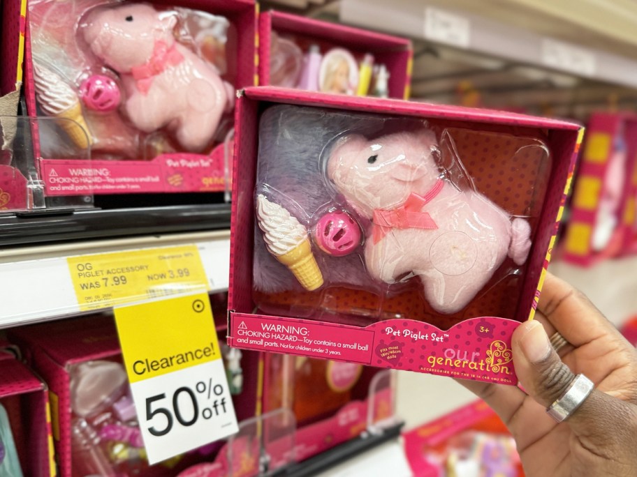 hand holding up Our Generation Pet Piglet Set near 50% off clearance sign