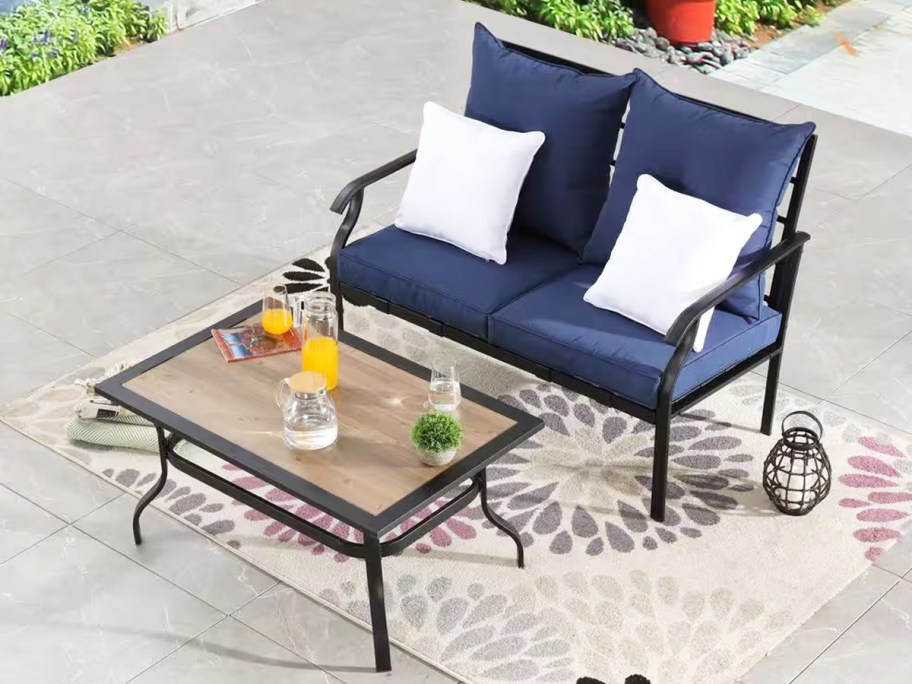 black patio chair with blue cushions and coffee table