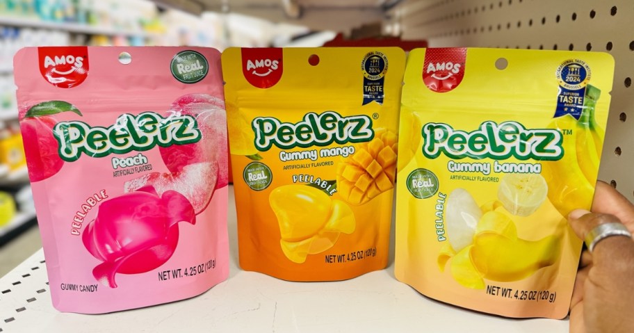 three bags of peelerz gummy candy in peach, mango, and banana on store shelf