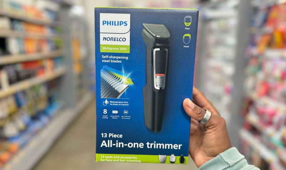 a womans hand holding an electric trimmer