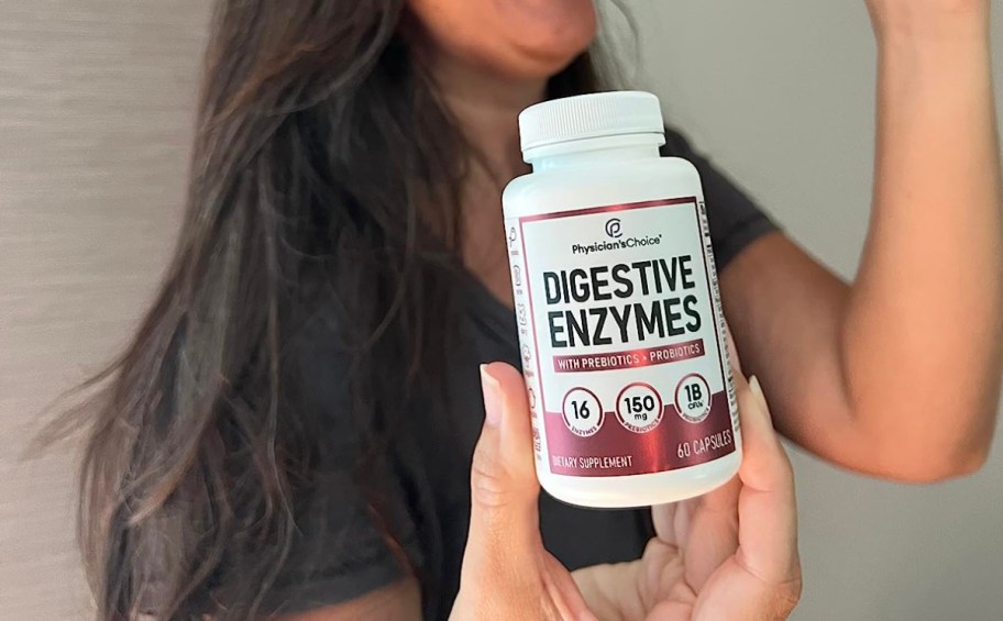 Woman holding bottle of digestive enzymes supplements 