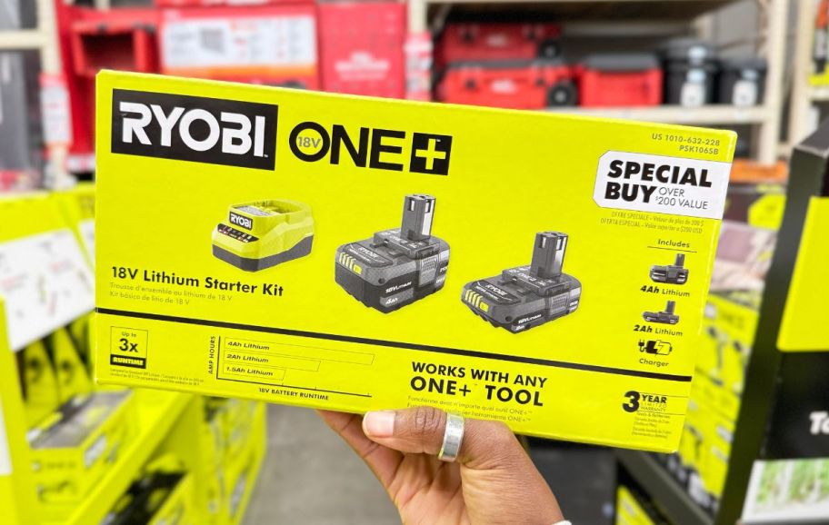 a womans hand holding a ryobi battery starte kit