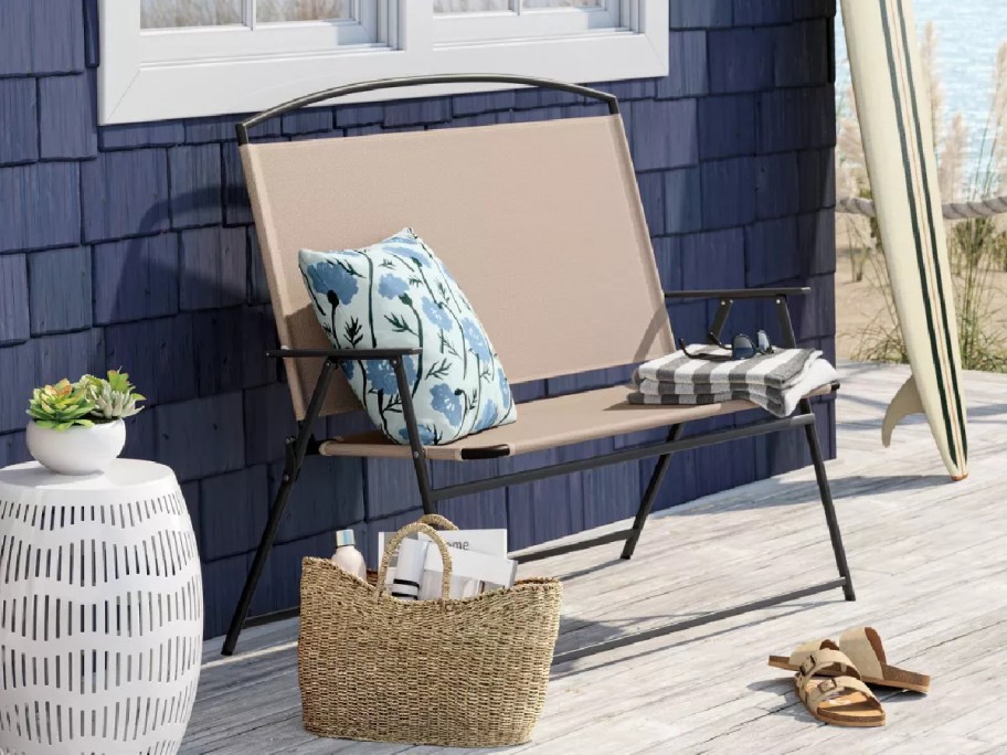 beige Room Essentials Portable Beach Chair and throw pillows against a dark house