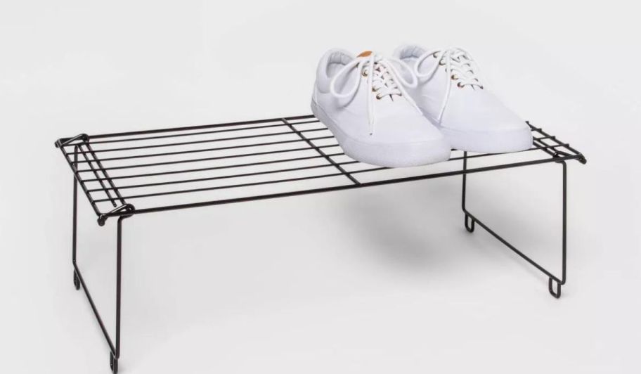 A pair of white sneakers on a Room Essentials Stackable Single Shoe Rack in Black