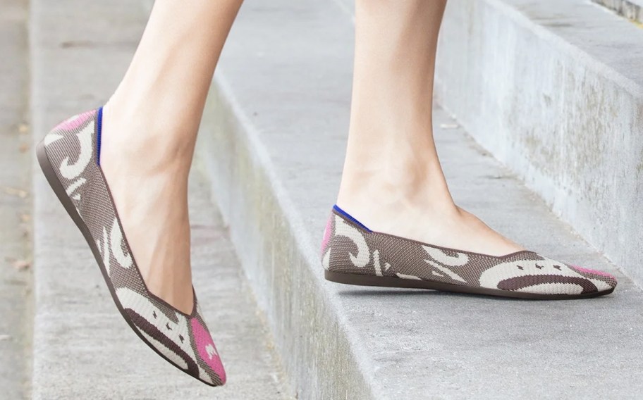 woman walking up stairs wearing brown and pink flats