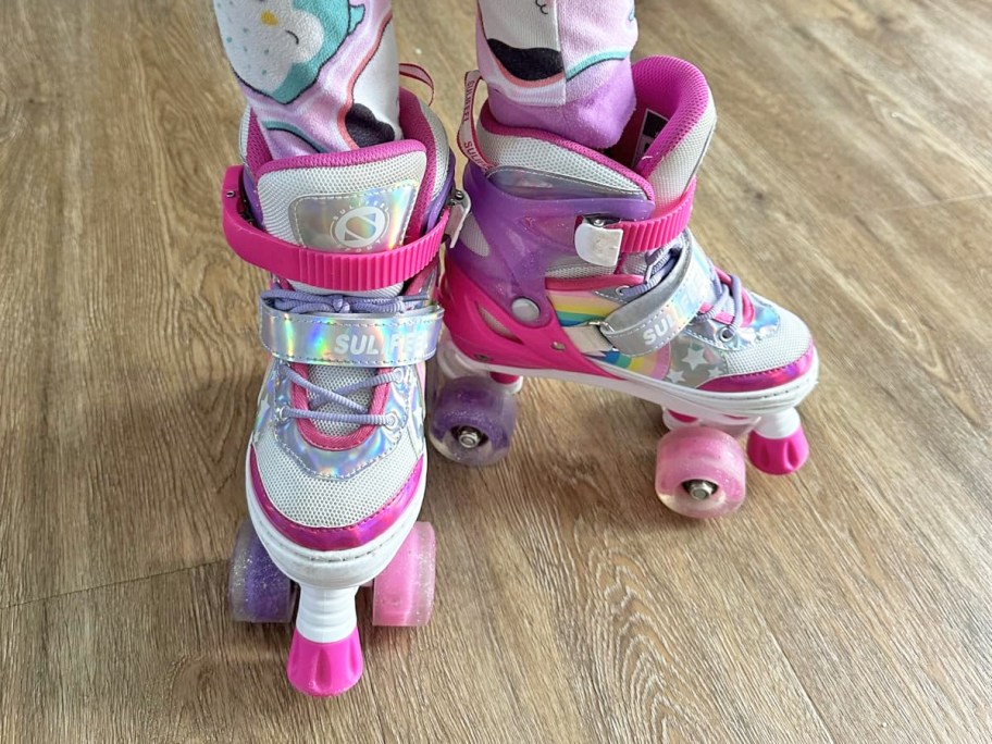 child wearing pair of pink and purple roller stakes