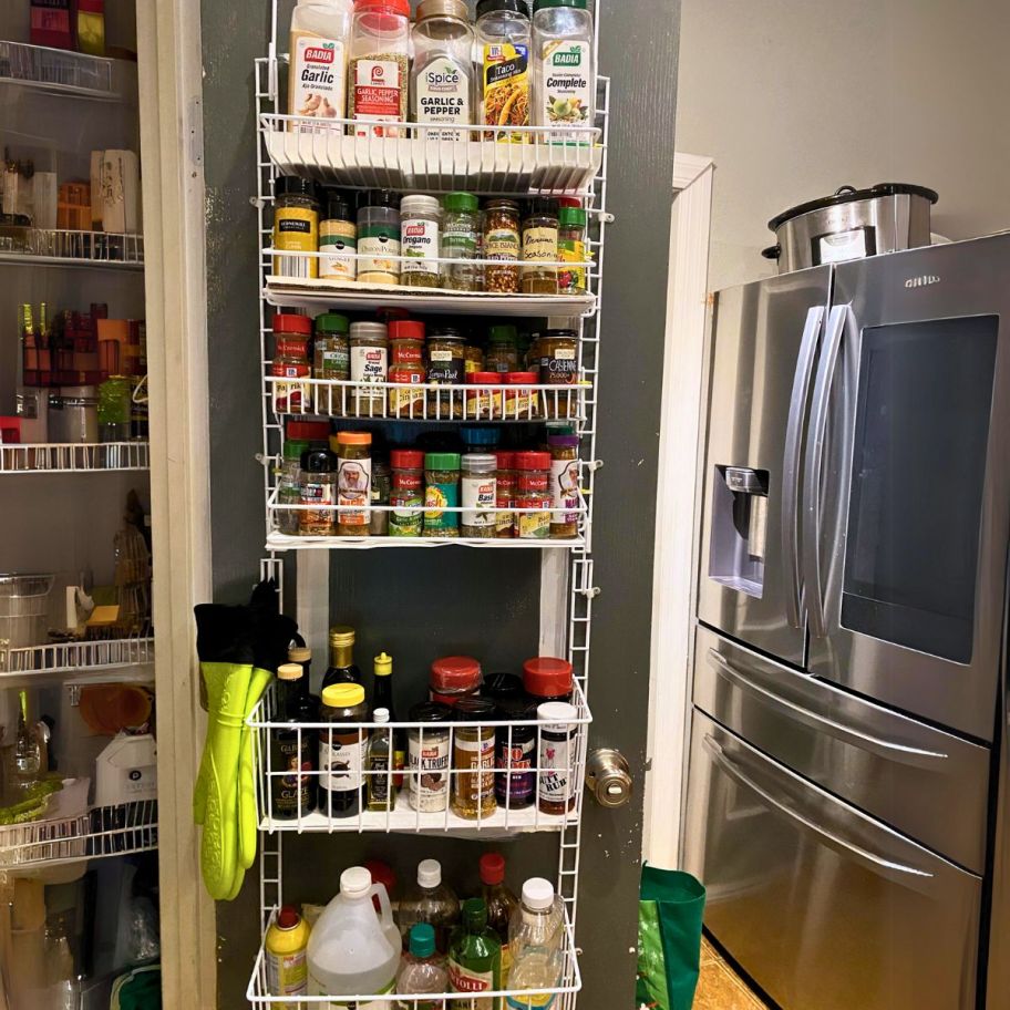 an over the door pantry organizer filled with items hanging on a pantry door.