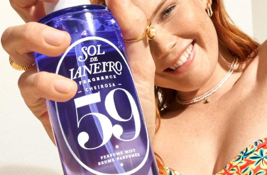 Sol de Janeiro perfume held in womans hand