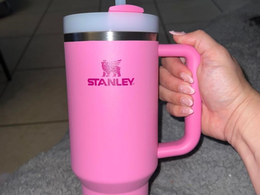 Hand holding a peony color stanley quencher tumbler