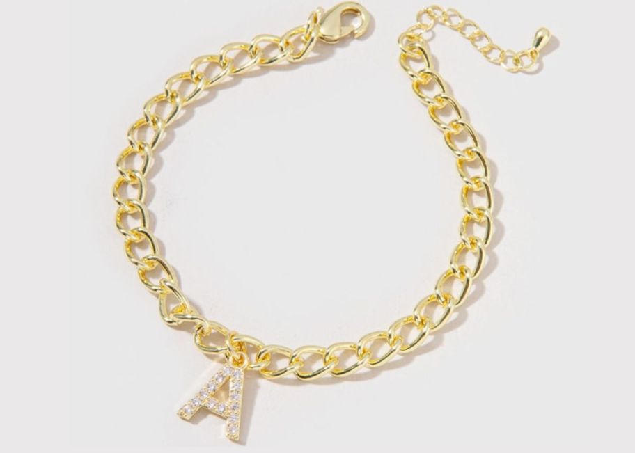 a gold chain bracelet with a cz letter A