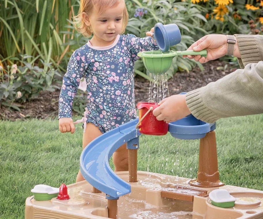 toddler girl playing with a Step2 Splashway Canal water table