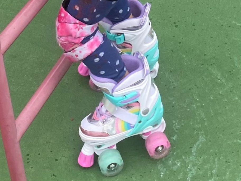 A child wearing a pair of adjustable roller skates in bright colors 