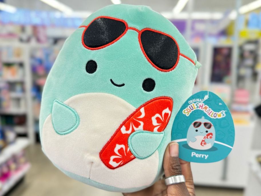 Hand holding a Perry Dolphin squishmallow