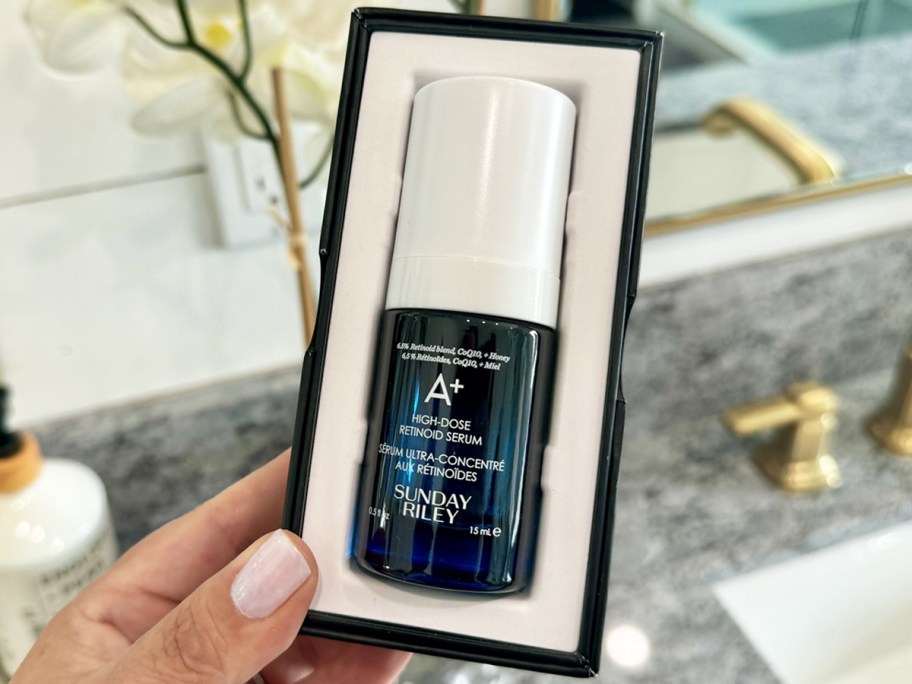hand holding a boxed blue bottle of Sunday Riley A+ High-Dose Anti Aging Retinol Serum