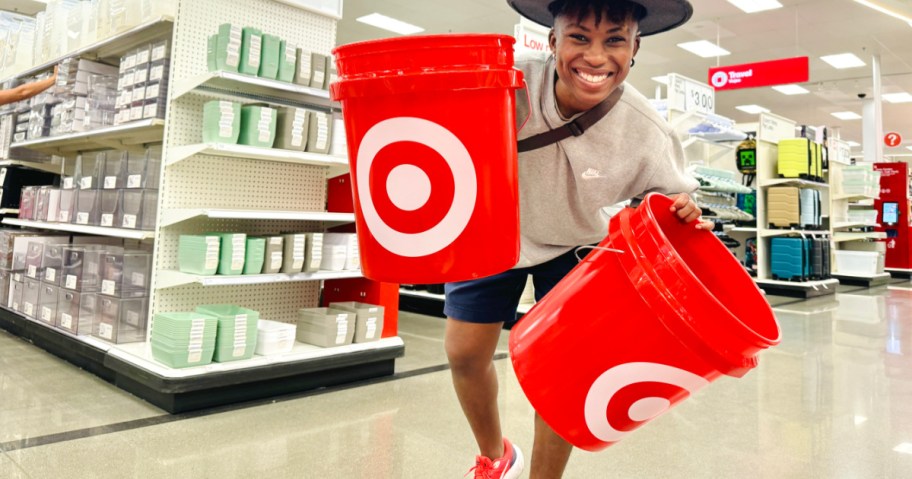 person holding 2 red target buckets inside store