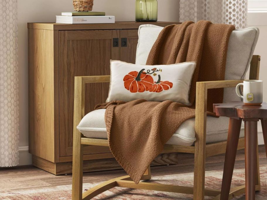 A chair with a brown throw blanket on it. 