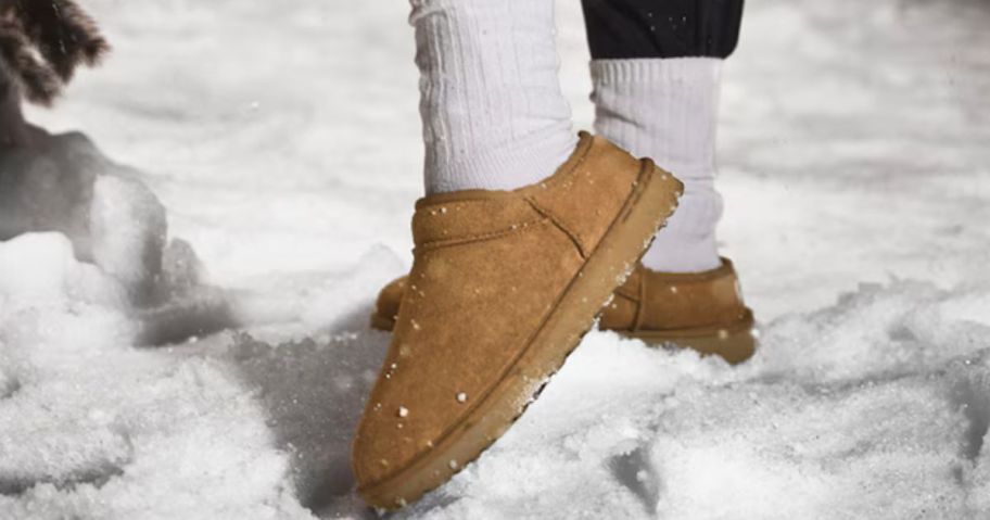 Feet wearing UGG slippers in the snow