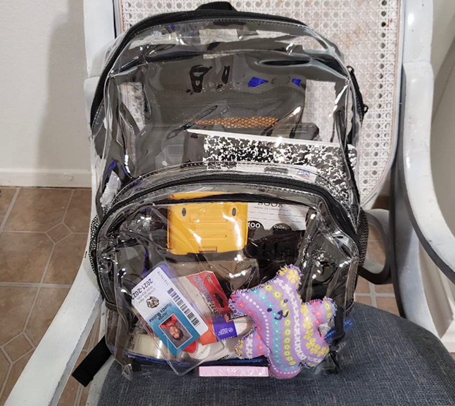 clear backpack stuffed with stuff sitting on chair