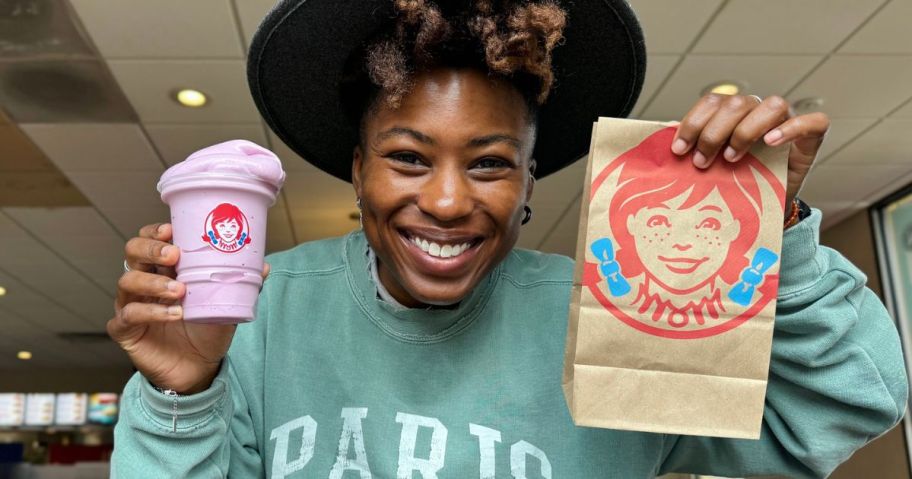Woman's holding a Wendy's berry Frosty and a wendy's bag