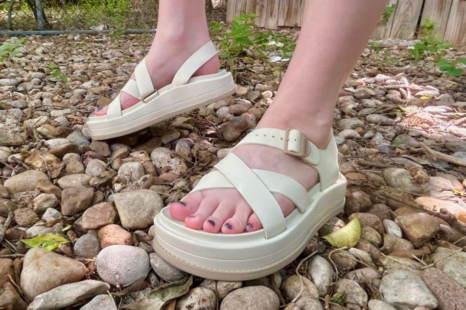 a woman wearing a pair of cream colored Chaco Townes Midform Sandals