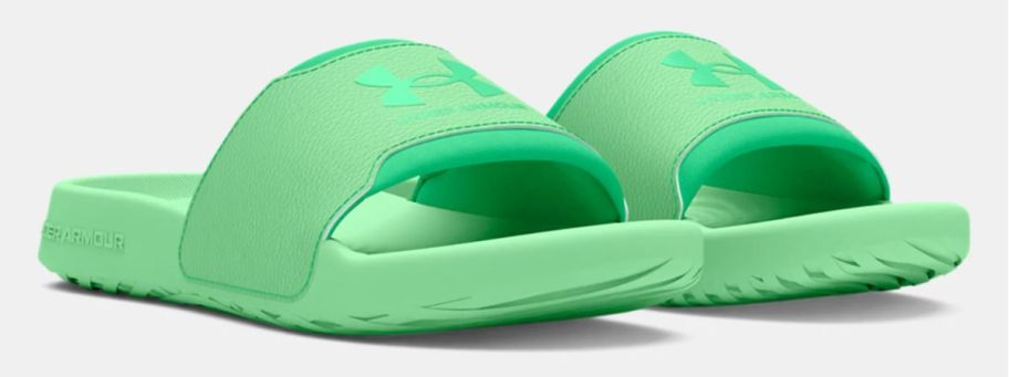a pair of green womens under armour slides