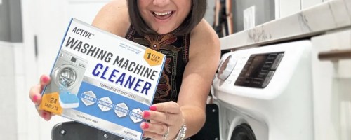 woman holding washing machine cleaner box near washer