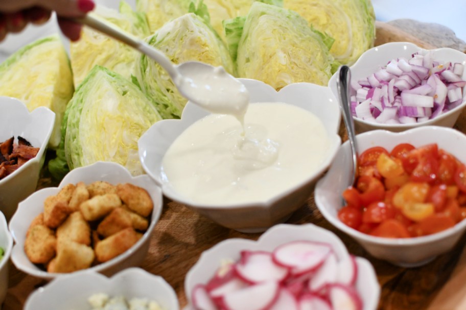 adding blue cheese dressing to wedge salad board