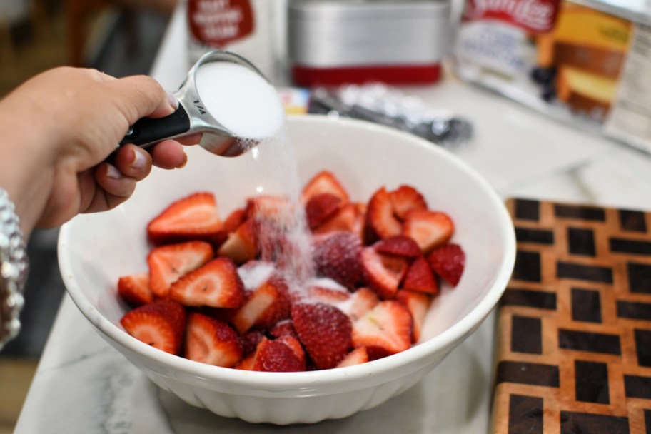 adding sugar to strawberries