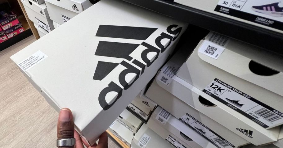 adidas shoe box being pulled by hand off of store shelf